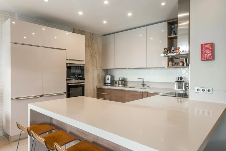 a modern kitchen with white cabinets, two barstools, and wood stools