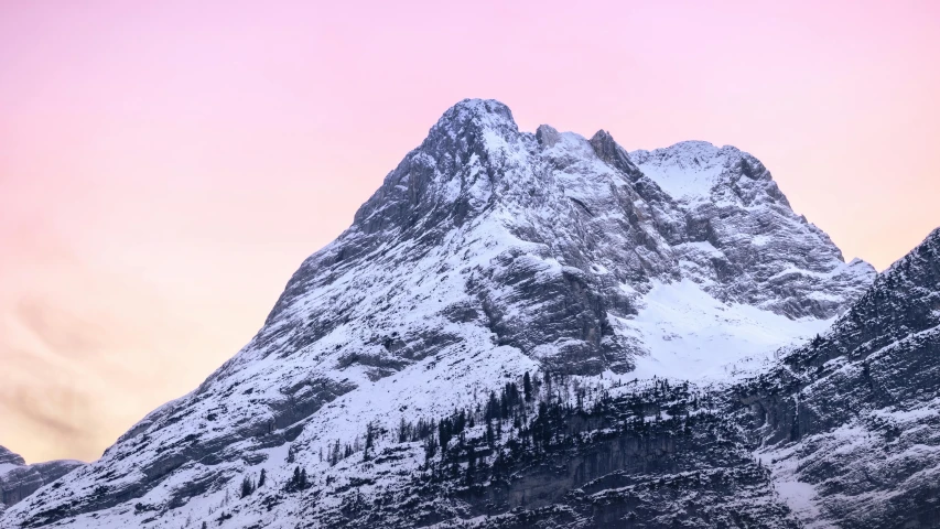 a very tall mountain towering over some snow