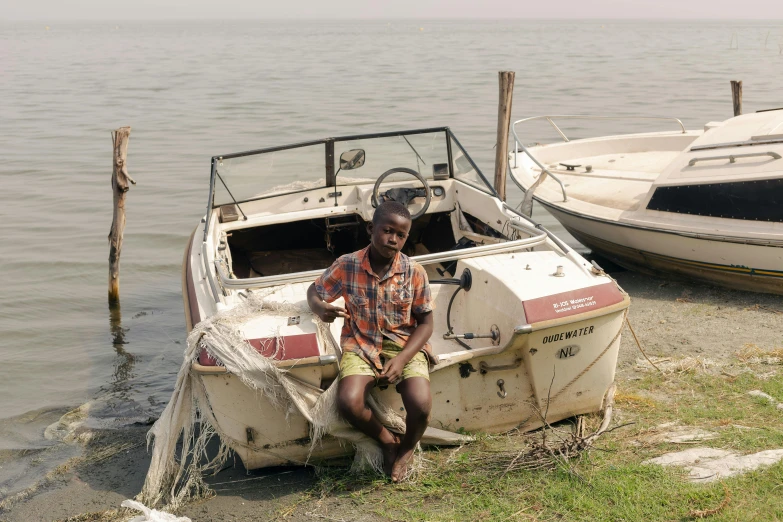 a man sitting in a boat sitting on the beach