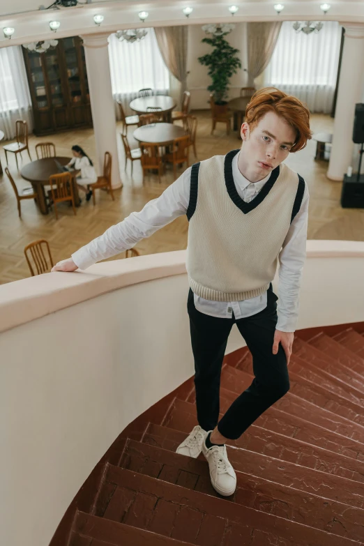 a young red headed woman standing next to an empty dining room