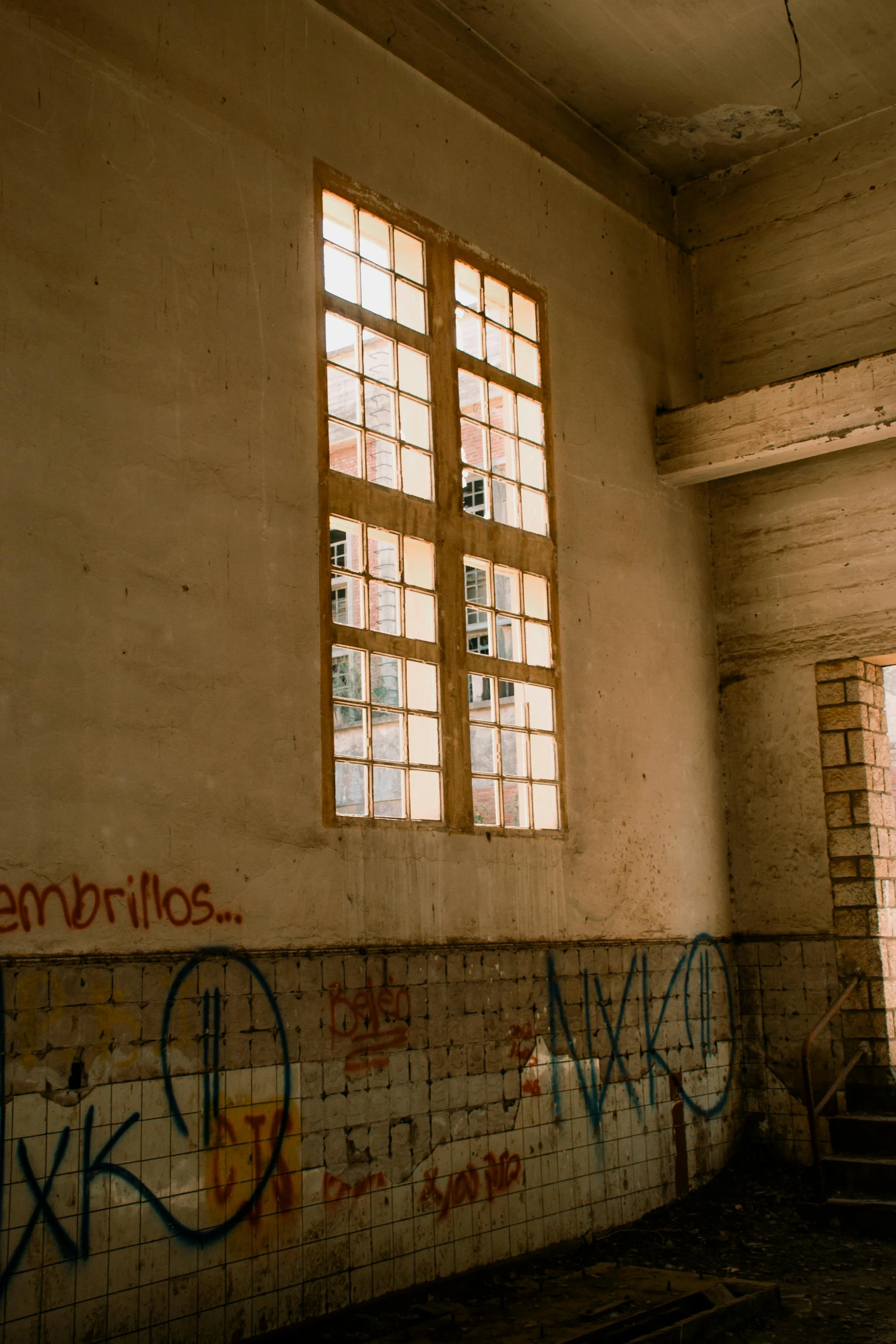 an old bathroom with graffiti on the walls and a window