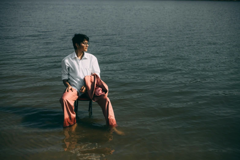 a man sitting in a chair in the water