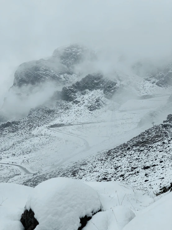 snow covered mountains in a foggy, snowy day