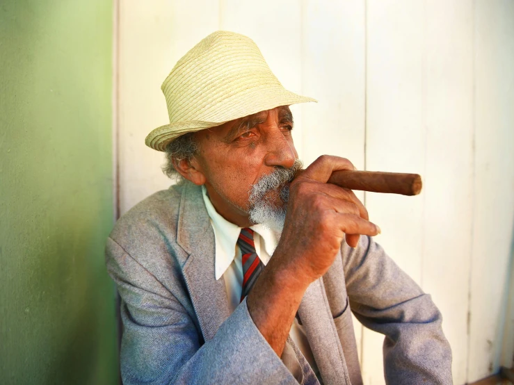 a man smoking a cigar wearing a straw hat