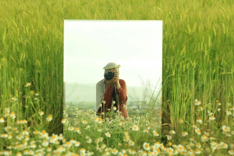 a mirror is shown with a person in a field
