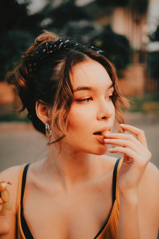 a woman wearing a yellow top, blowing into her mouth