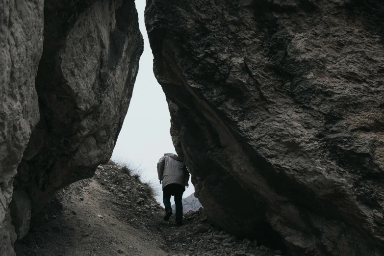 two people walk up an old road between two large rocks