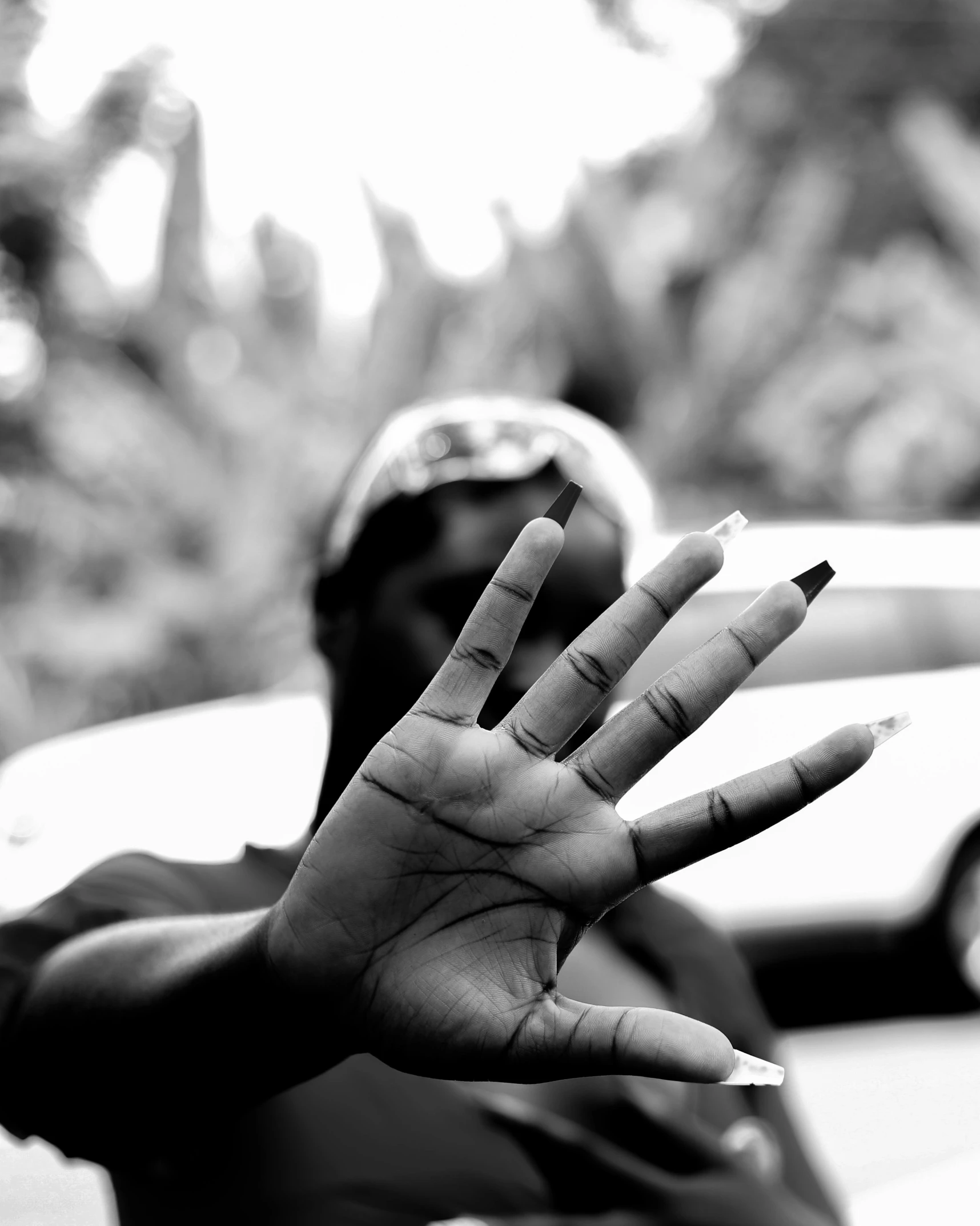 a hand gesture with black and white image of car