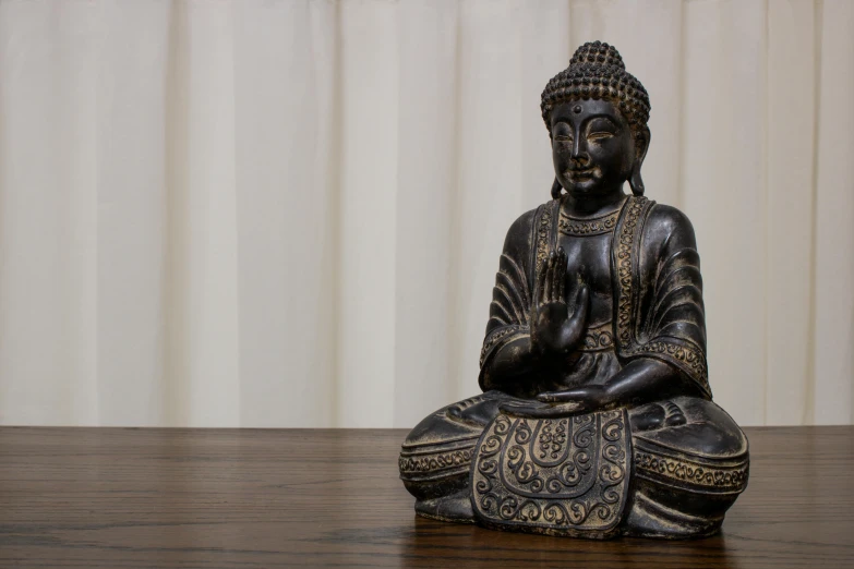 a close up of a buddha statue on a table