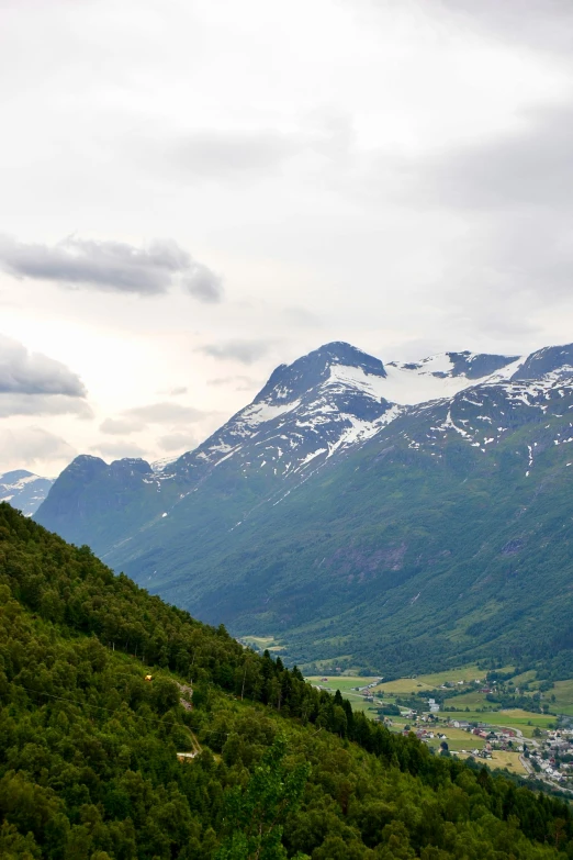 a person sitting on top of a mountain with snow on the tops