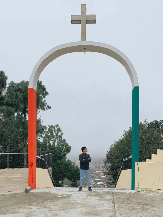 man standing on dirt under an archway looking at the sky