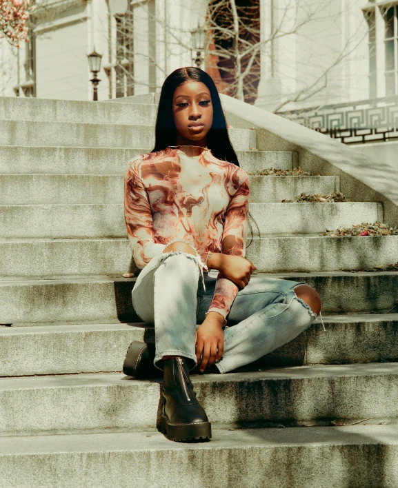 a woman is sitting on the steps in front of a building