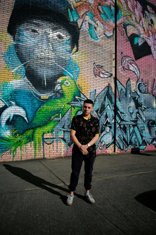a person that is standing up in front of a wall with grafitti