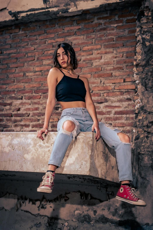 a woman wearing ripped jeans and a cropped top