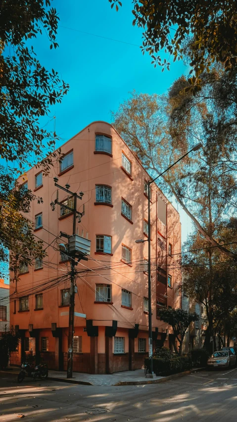 a tall building surrounded by trees on a street corner