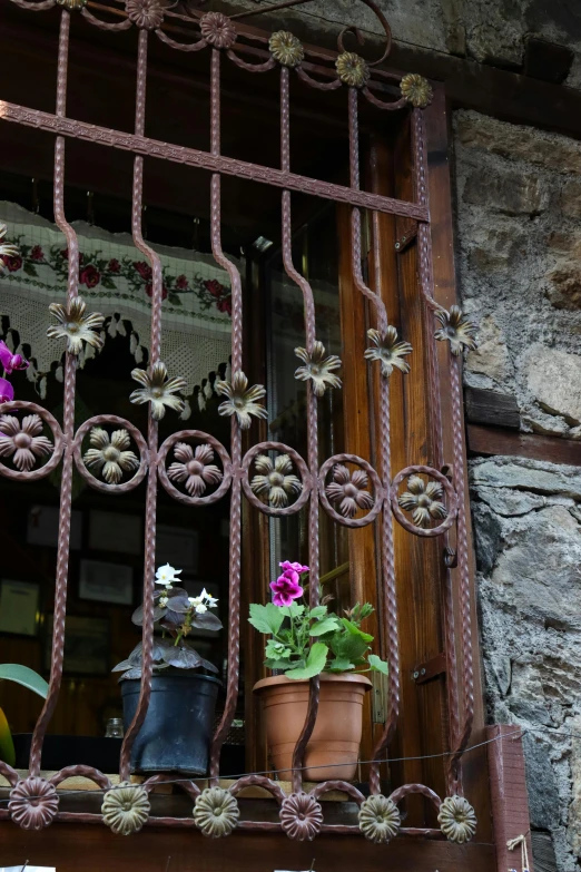 a window with flower pots and decorative wire work