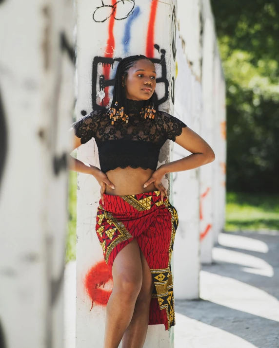 a woman standing against the wall in a skirt