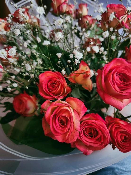 a bouquet of red roses in the middle of a clear vase