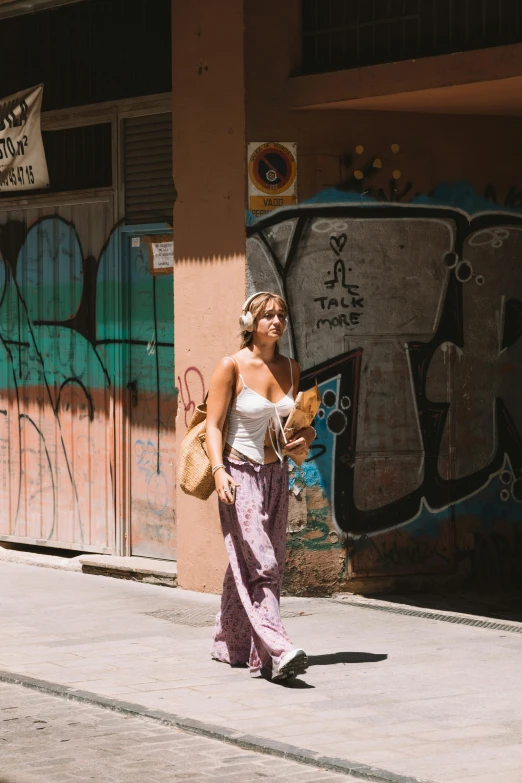 a woman stands on the side of the road while using a cell phone