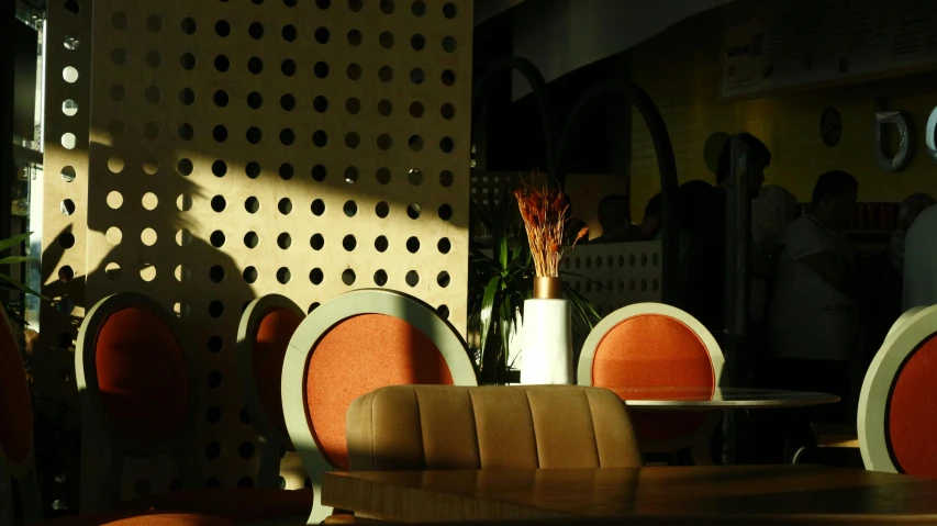 a dining table is set with orange chairs