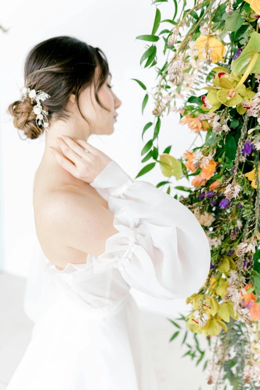 the bride in a wedding dress next to flowers