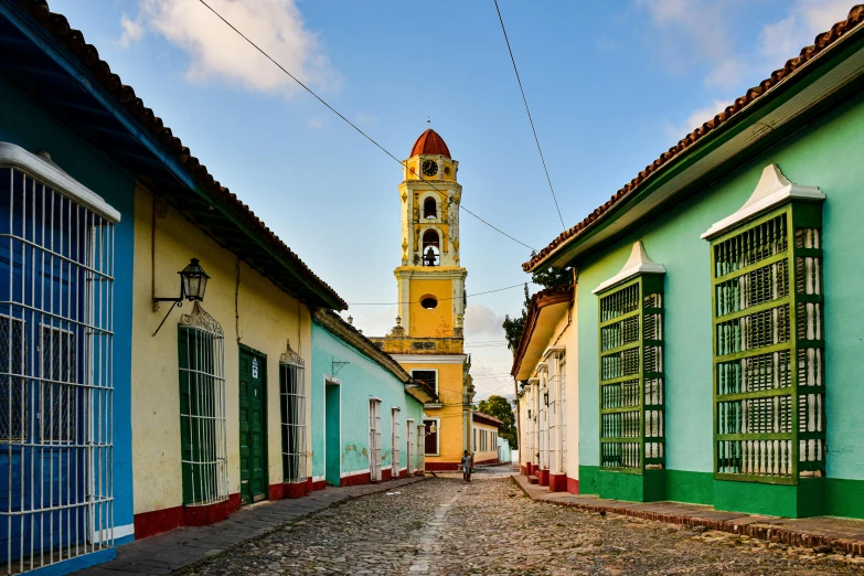 an old narrow street with blue doors and green buildings