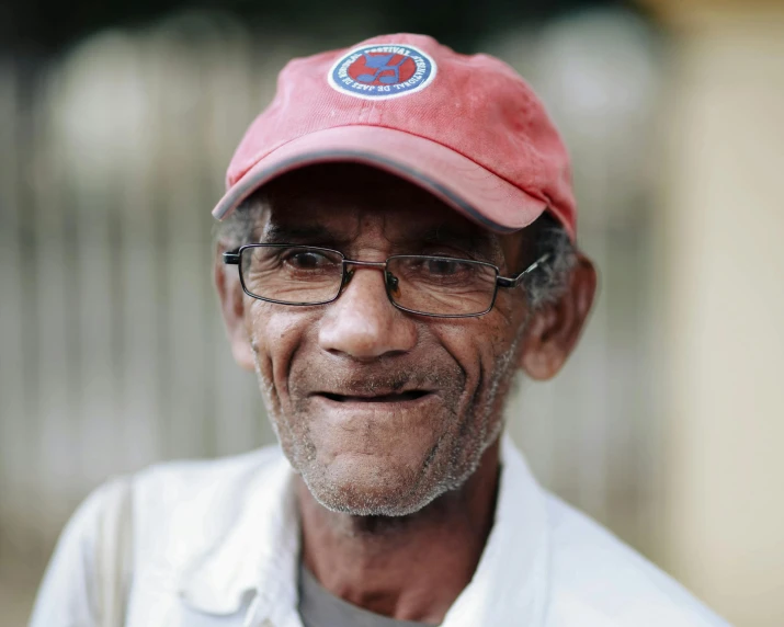 a man wearing glasses, a red hat and a white shirt