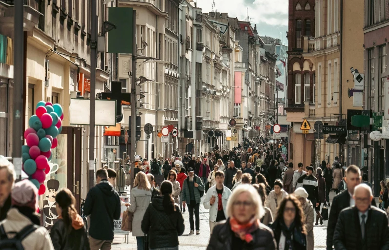 a crowded city with many people walking down the road