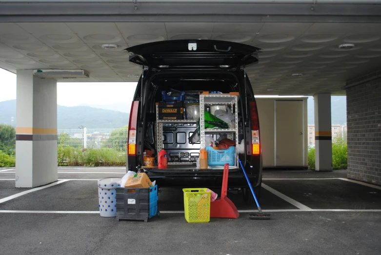 people are loading up luggage onto the back of a van