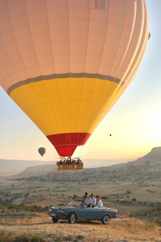 people are in the backseat of a vehicle in front of a large  air balloon