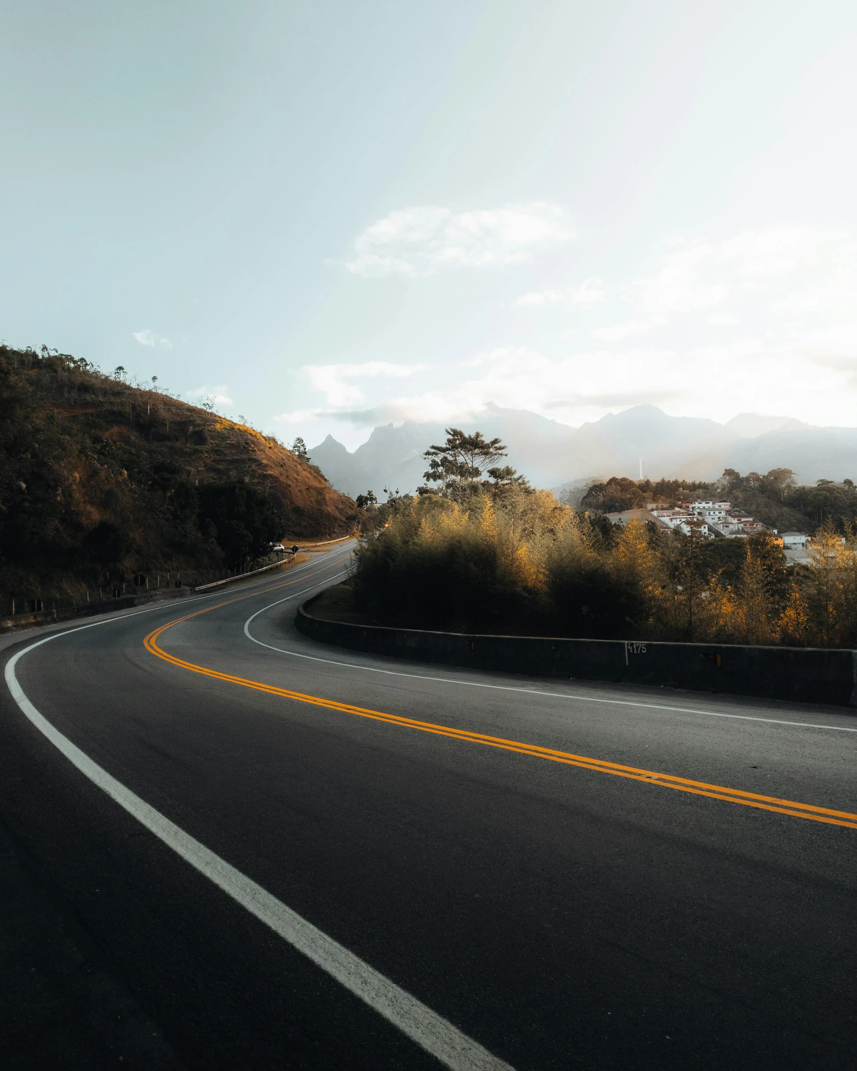 a curved road is shown in the middle of some hills