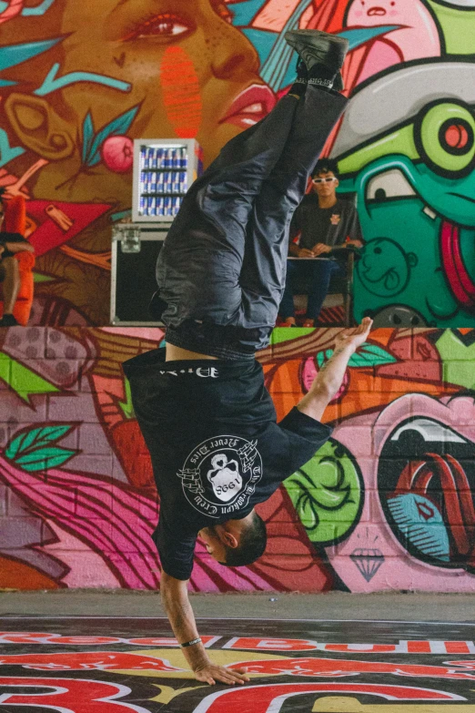 a man doing a yoga exercise in front of a mural