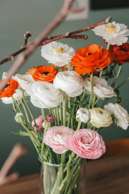 the bouquet of flowers in the glass vase is on the table