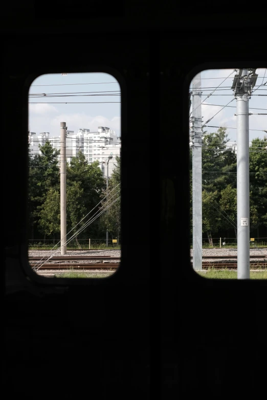 looking out the window at a railroad track near a train station