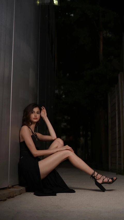 woman in black dress sitting down in an empty room