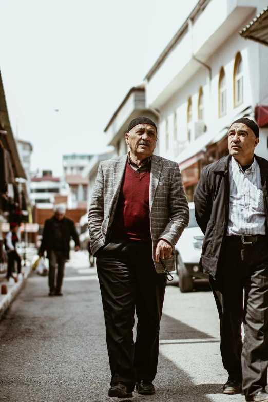 a man and a woman walking down the sidewalk on a busy street