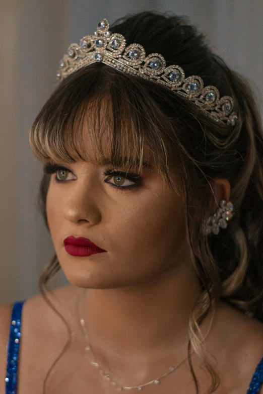 a woman with dark red lipstick and a tiara