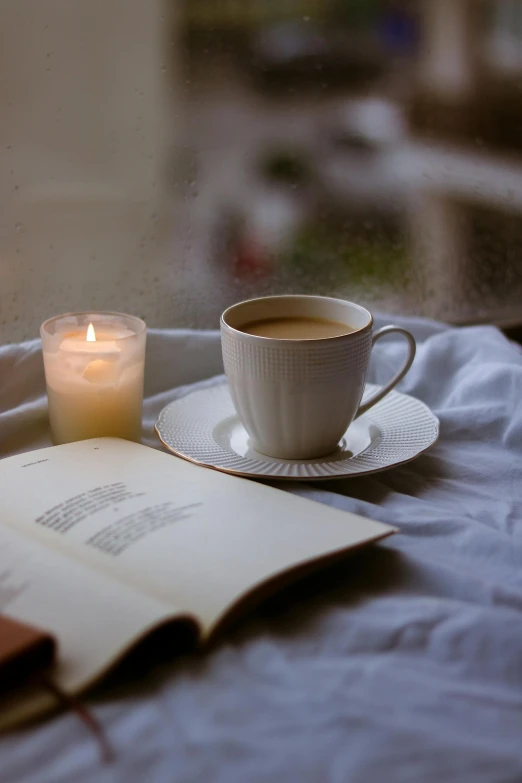 the candle is placed next to a cup of coffee