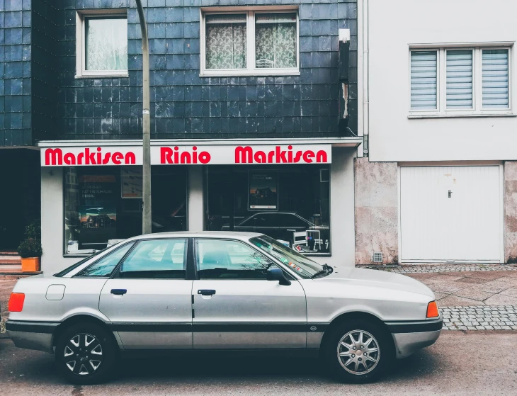 a car parked outside of a store near a building