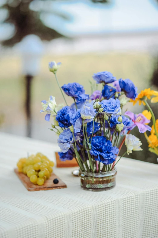 a small glass vase filled with blue and yellow flowers