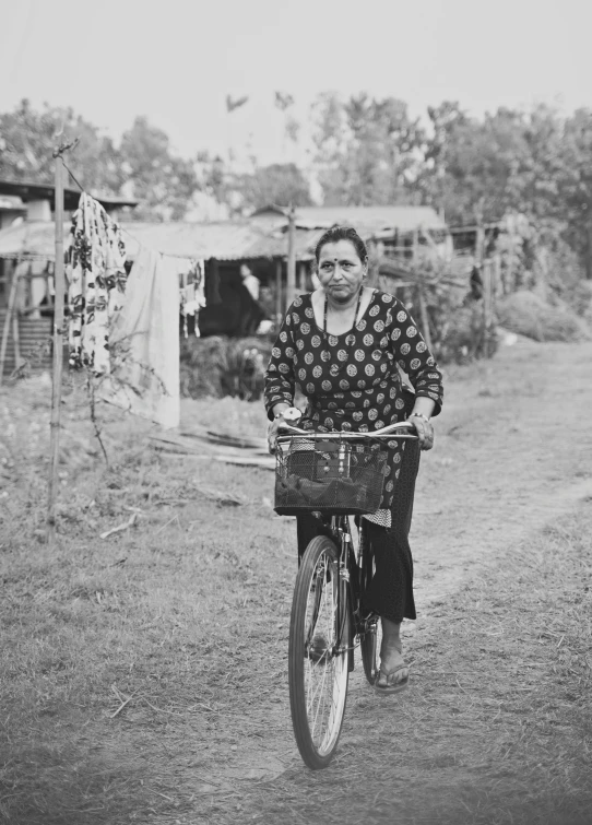 woman on bicycle with basket in rural area