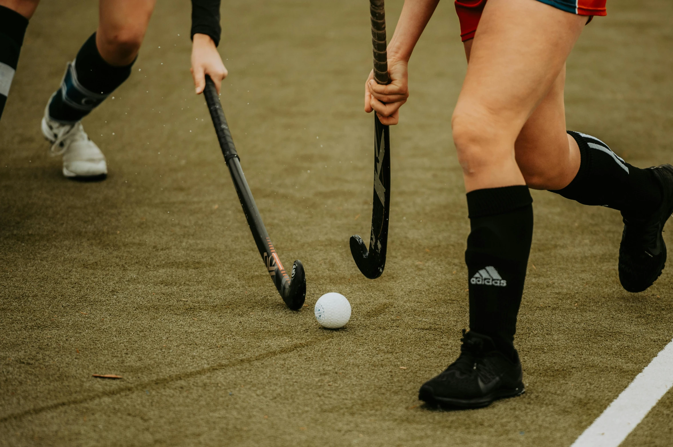 close - up s of two women's playing field hockey