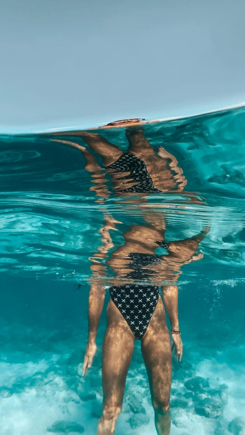 the woman is standing in the water with her back turned