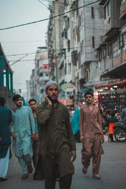 a man talking on the phone walking down a city street