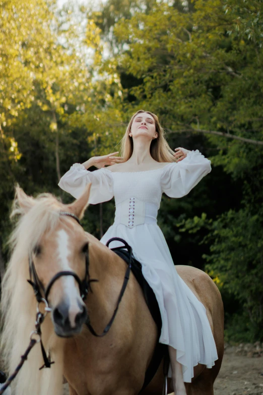 a girl in a white dress rides on a horse