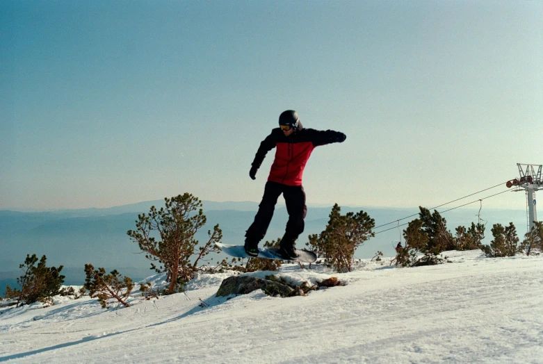 a snowboarder that is doing a trick on a hill