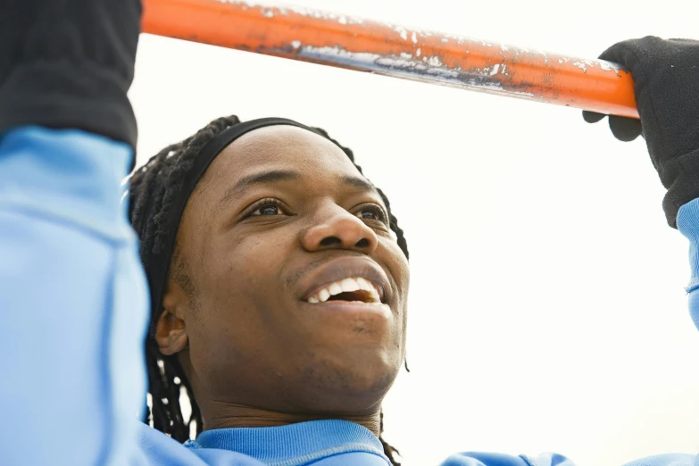 woman holding an orange bat up to her head