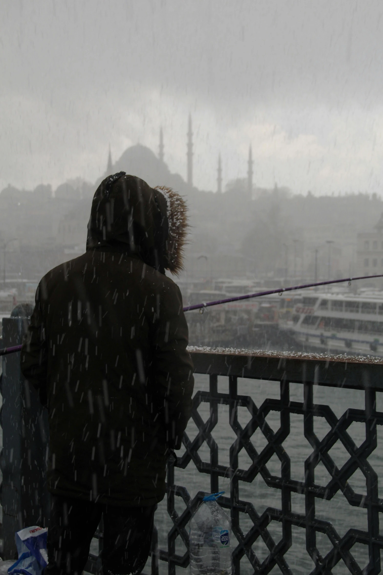 man looking out over a city on a snowy day