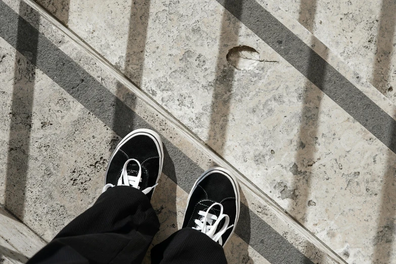 a man standing with black tennis shoes on