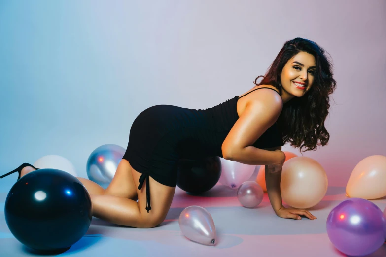 the woman is posing with balloons on her feet